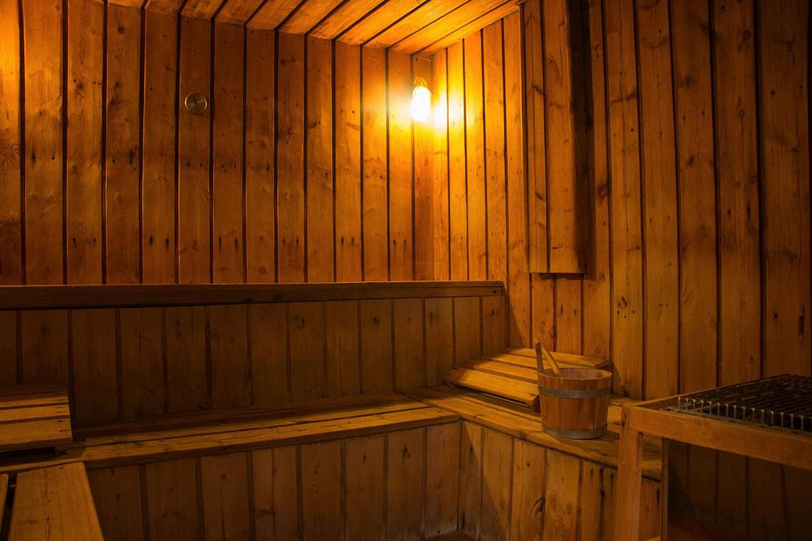 Holzsauna im LABRANDA Club Paradisio El Gouna mit warmem Licht und einem Holzeimer
