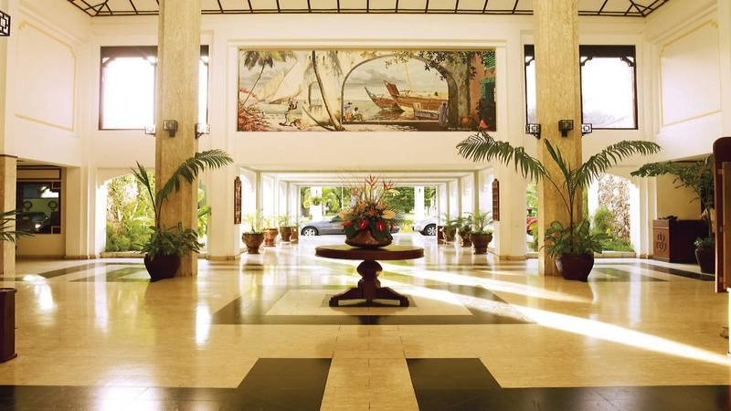 Foyer des Sarova Whitesands Beach Resort & Spa mit zentralem Tisch, Pflanzen und Gemälde.