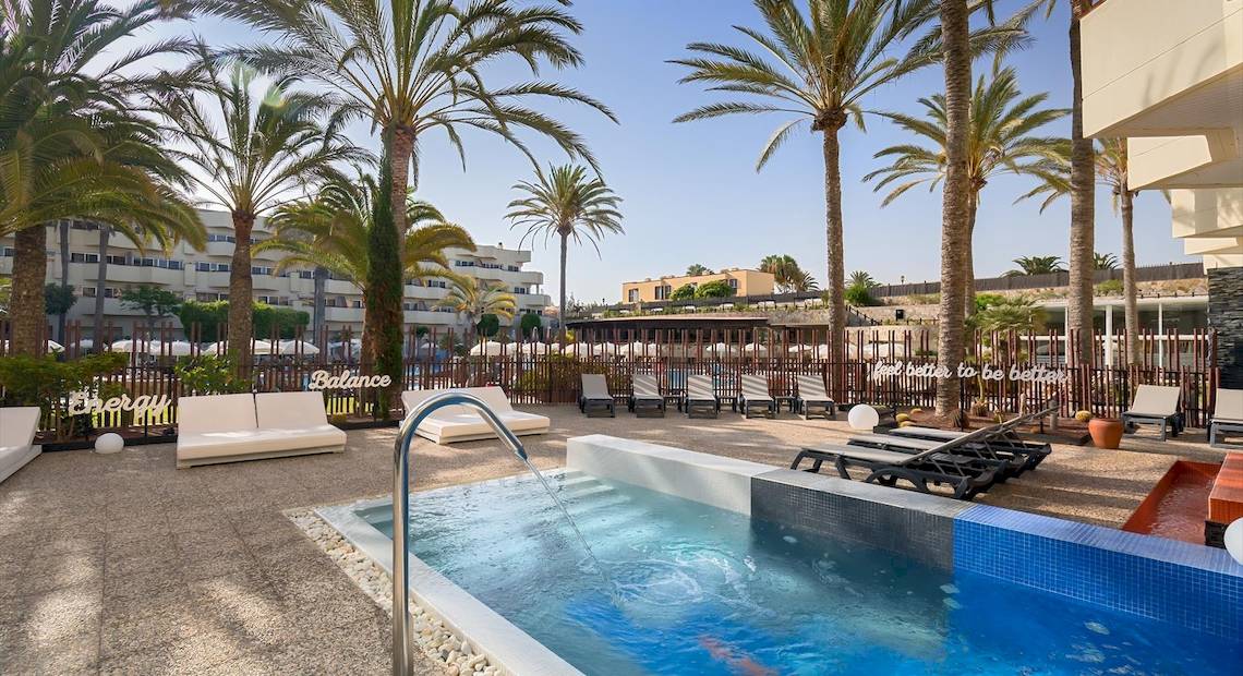 Außenpool mit Loungeliegen und Palmen im Barcelo Corralejo Bay Hotel.