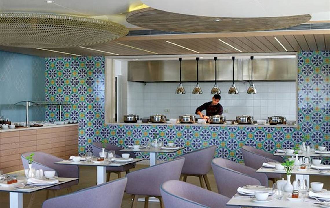 Restaurant im Atlantica Imperial Resort & Spa mit bunten Wandfliesen und einer Person, die hinter der Theke steht.