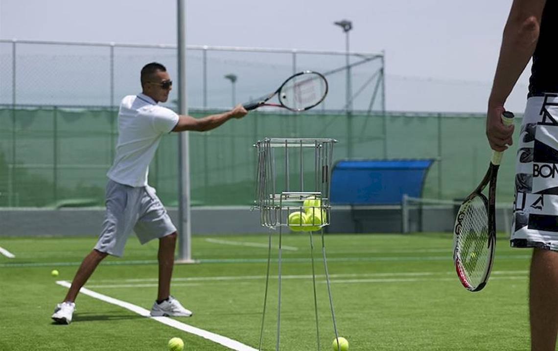 Tennisspieler im Training auf dem Platz, Tennisschläger haltend und auf einen Ball schlagend.