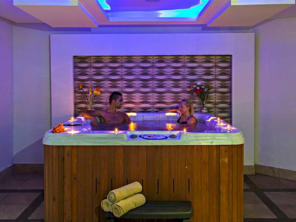 Paar in einem beleuchteten Jacuzzi im Serenity Alma Heights Hotel.