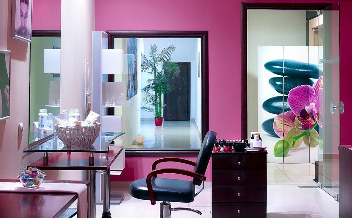 Friseursalon im Michelangelo Resort und Spa mit Stühlen, Schreibtisch und Spiegel.