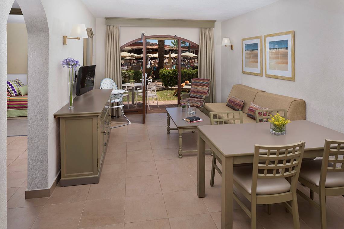Innenansicht der Suite im HD Parque Cristobal Hotel mit Wohnzimmer und Essbereich.