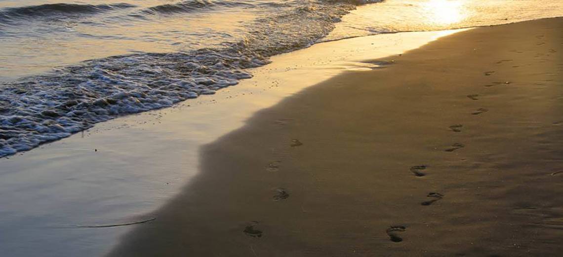 Foto von einem Strand mit Fußabdrücken im Sand bei Sonnenuntergang am HD Parque Cristobal Hotel.