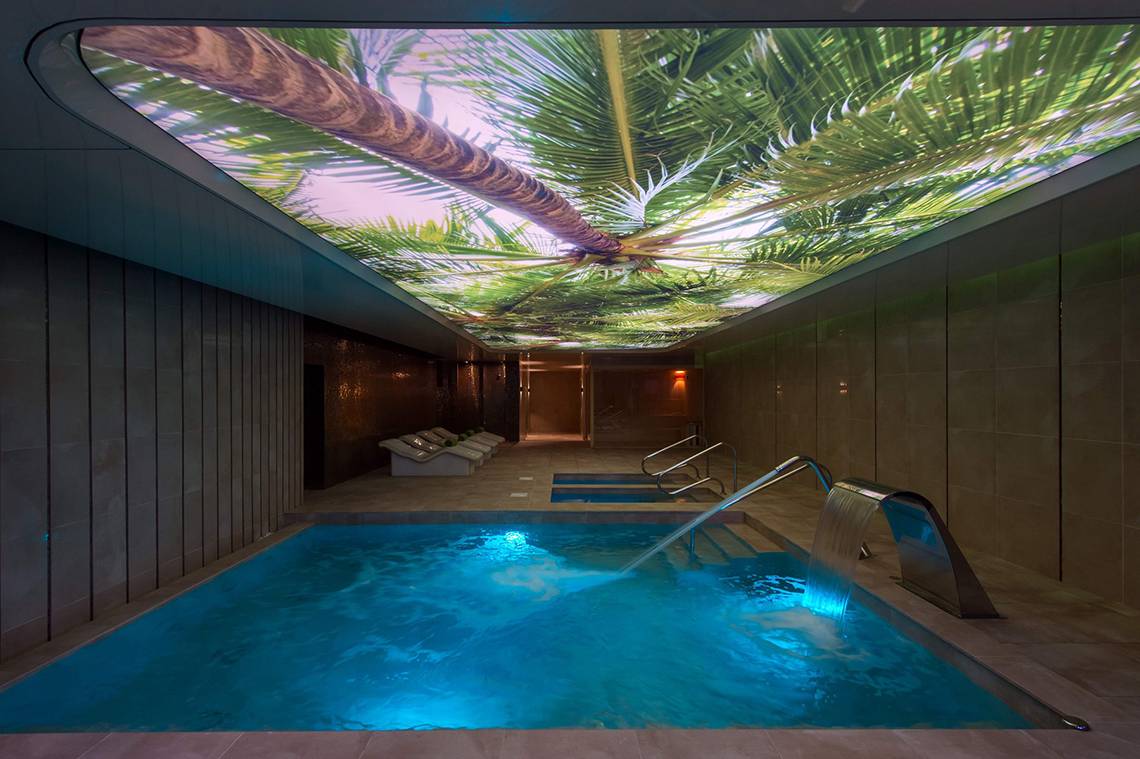 Innenpool im HD Parque Cristobal mit Palmenbaumprojektion an der Decke.