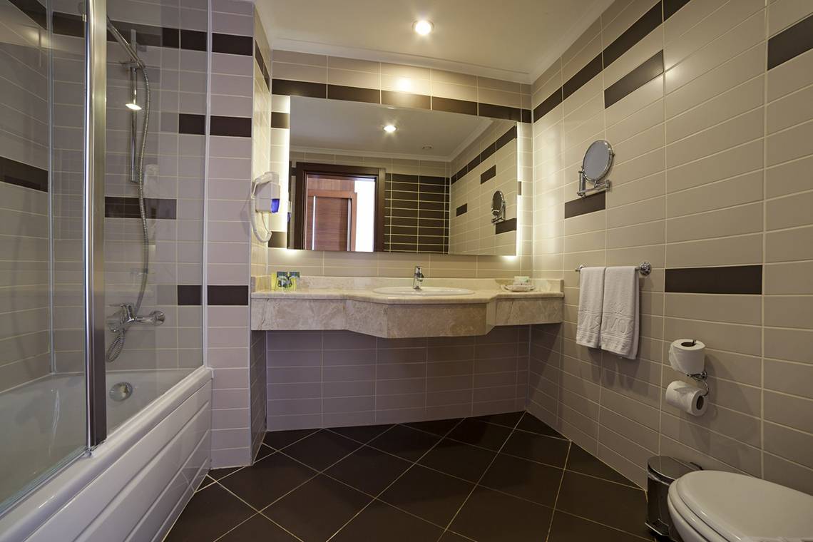 Ein Badezimmer mit einer Dusche, einem Spiegel und Toilettenpapierhalter.
