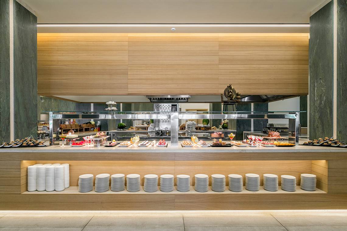 Buffetbereich im Amada Colossos Resort mit verschiedenen Gerichten und vielen Tellern.