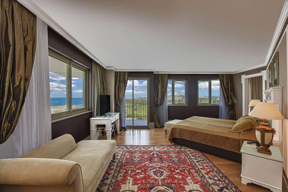 Suite Zimmer im Delphin Diva Premiere Hotel mit Meerblick, Doppelbett, Sofa und Fernseher.