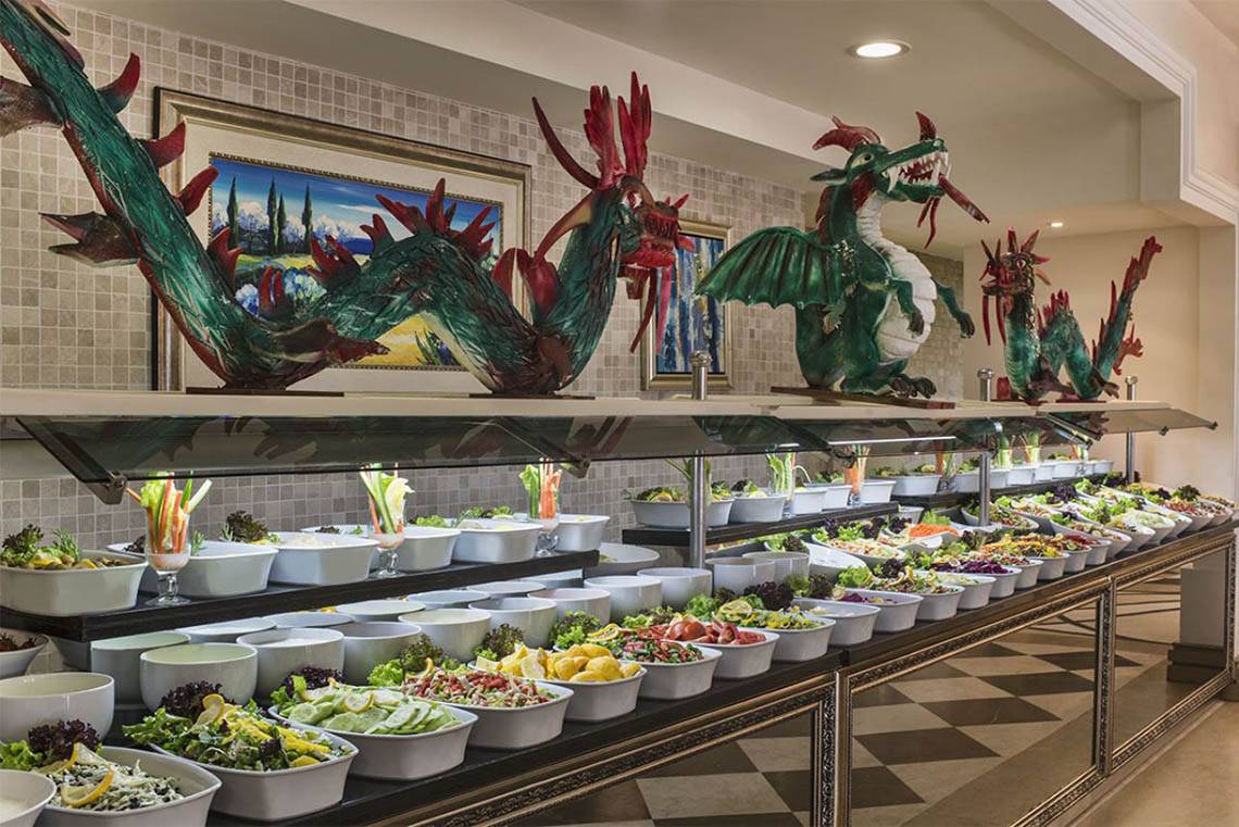 Buffet Saal im Delphin Diva Premiere Hotel mit verschiedenen Salaten und Drachenskulpturen.