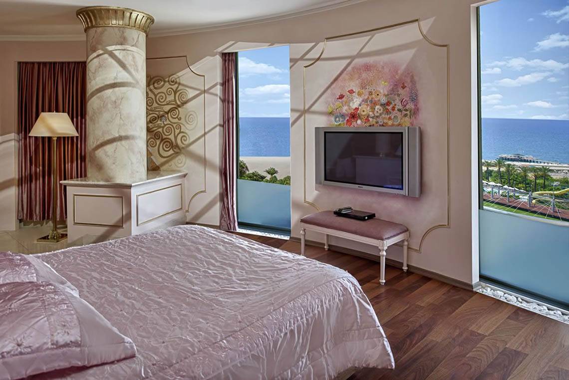 Schlafzimmer im Delphin Diva Premiere Hotel mit Meerblick und modernen Möbeln.