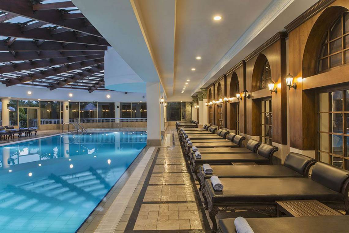 Im Delphin Diva Premiere Hotel gibt es einen großen Poolbereich mit Liegestühlen und einer Glasüberdachung.