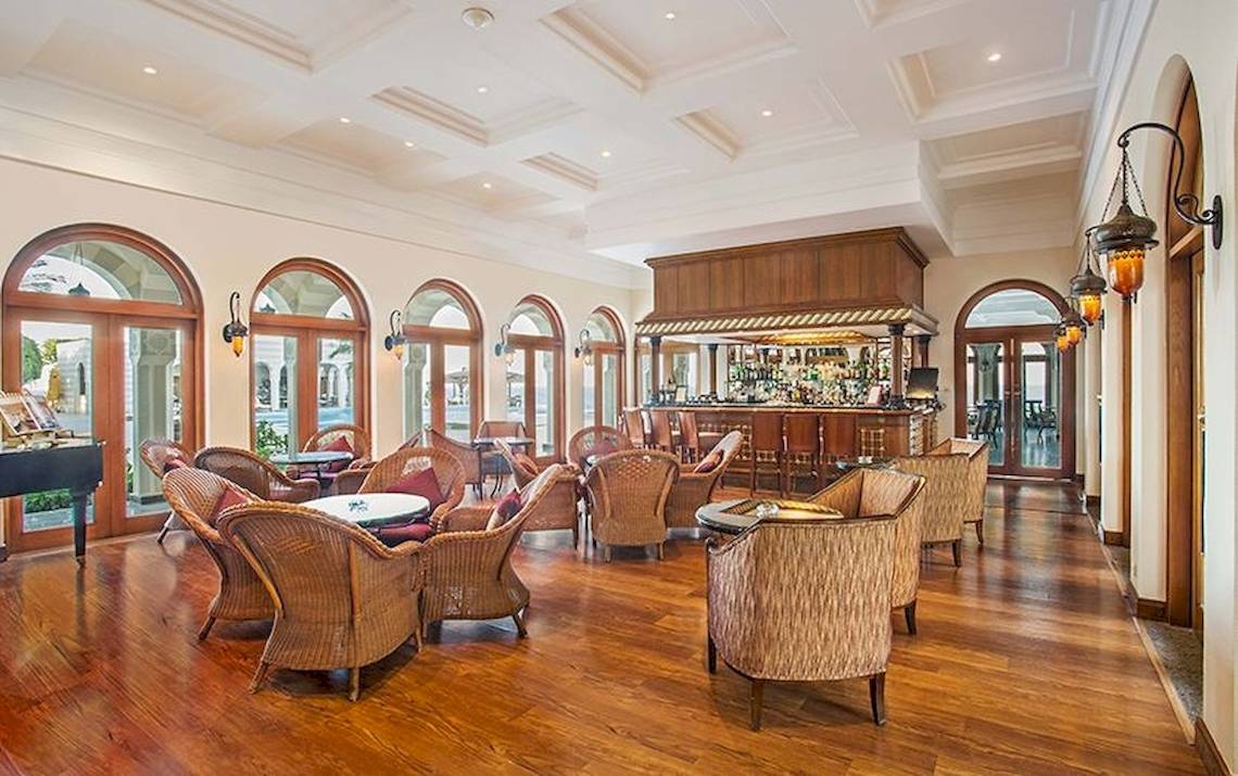Lounge im Oberoi Beach Resort mit Holzböden und Rundbogenfenstern.