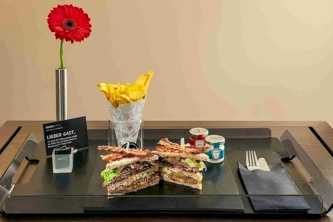 Zimmerservice Angebot vom NH Berlin Alexanderplatz mit Sandwich, Pommes und Getränk.
