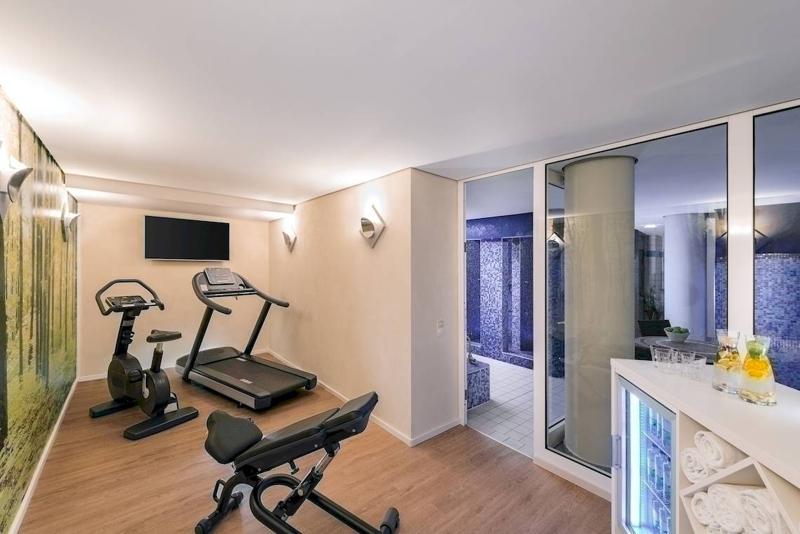 Fitnessraum im NH Berlin Alexanderplatz mit Trainingsgeräten und moderner Einrichtung.