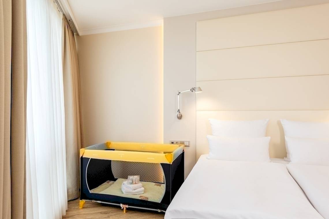 Hotelzimmer im NH Berlin Alexanderplatz mit zwei Betten und einem Kinderbett