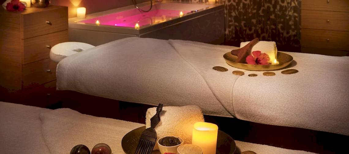 Spa-Behandlungsraum im Hilton Cabo Verde Sal Resort mit zwei Massageliegen, Whirlpool und Kerzen