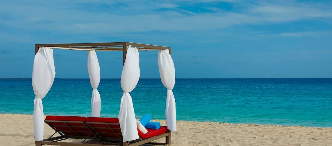 Liegestuhl auf dem Strand des Hilton Cabo Verde Sal Resorts mit Blick auf das Meer.
