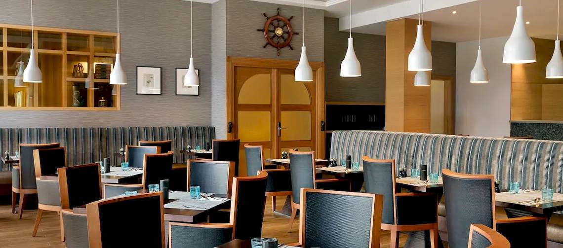 Restaurant im Hilton Cabo Verde Sal Resort mit Tischen, Stühlen und Dekorationen