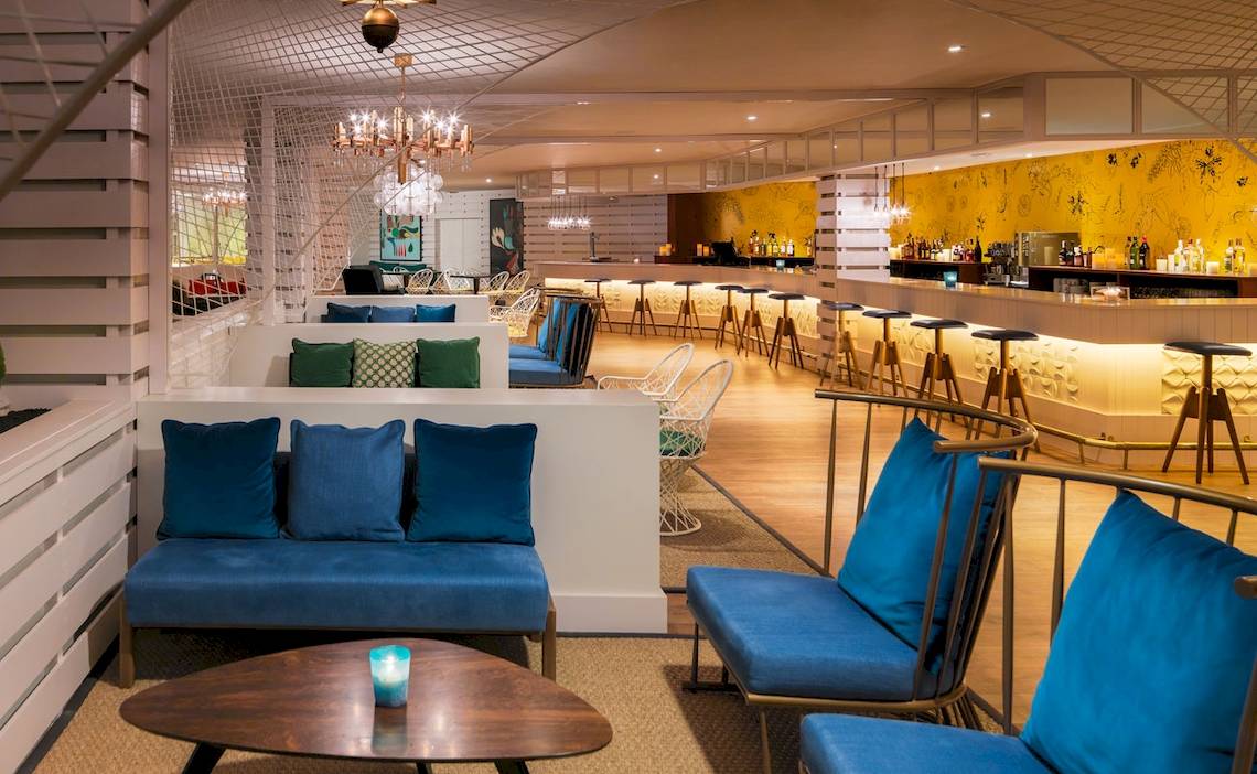 Loungebereich des H10 Lanzarote Princess Hotels mit blauen Sesseln und Bar im Hintergrund.