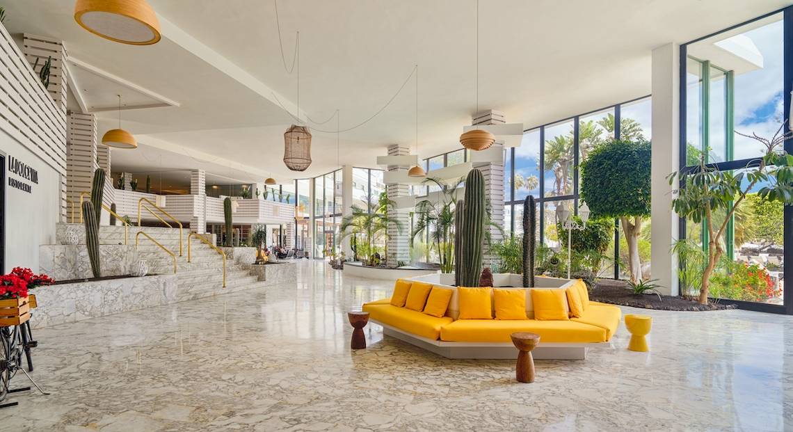 Lobby des H10 Lanzarote Princess Hotels mit gelben Sofas, hängenden Laternen und Pflanzen