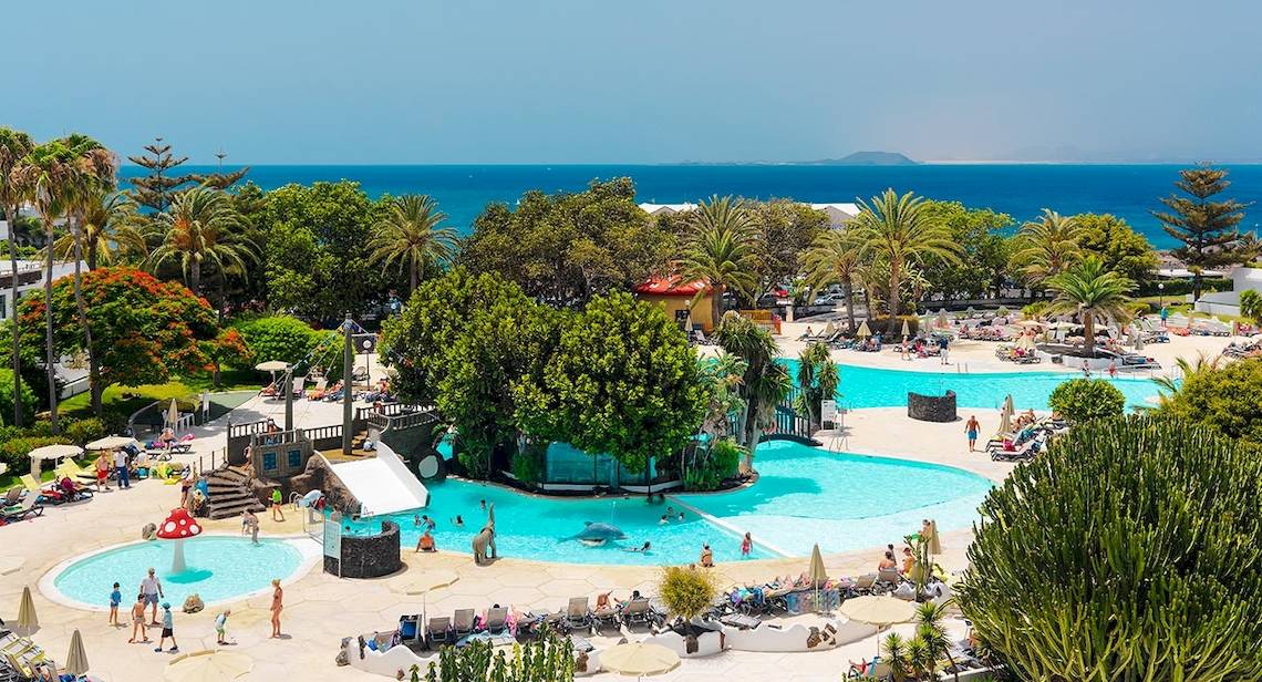 Luftaufnahme des H10 Lanzarote Princess Hotels mit großen Swimmingpools und vielen Gästen.