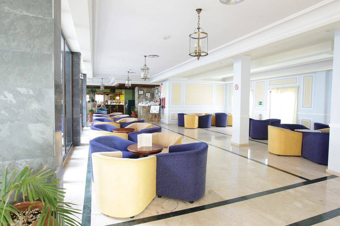 Lobby des AluaSoul Orotava Valley Hotels mit blauen und gelben Sesseln und Tischen.