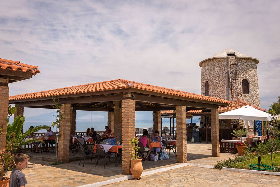 Terrasse im Pavlina Beach Hotel mit Blick auf das Meer und Berge.