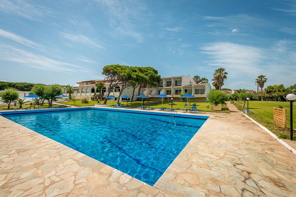 Außenpool des Pavlina Beach Hotels mit umliegenden Liegestühlen und Gebäuden