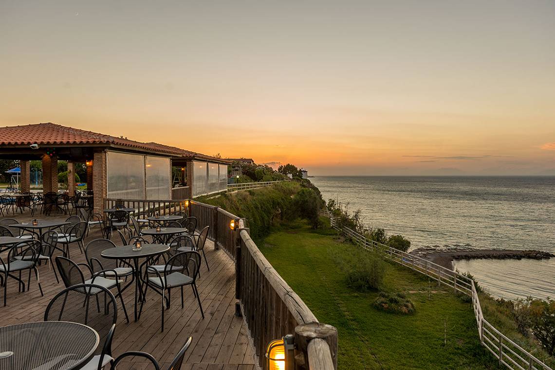 Terrasse des Pavlina Beach Hotels mit Blick auf das Meer bei Sonnenuntergang.