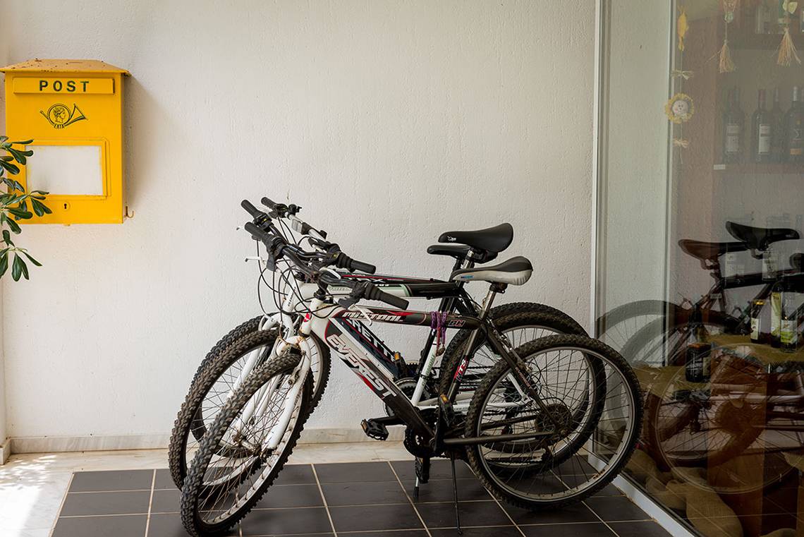 Fahrräder vor einer gelben Postbox im Pavlina Beach Hotel.