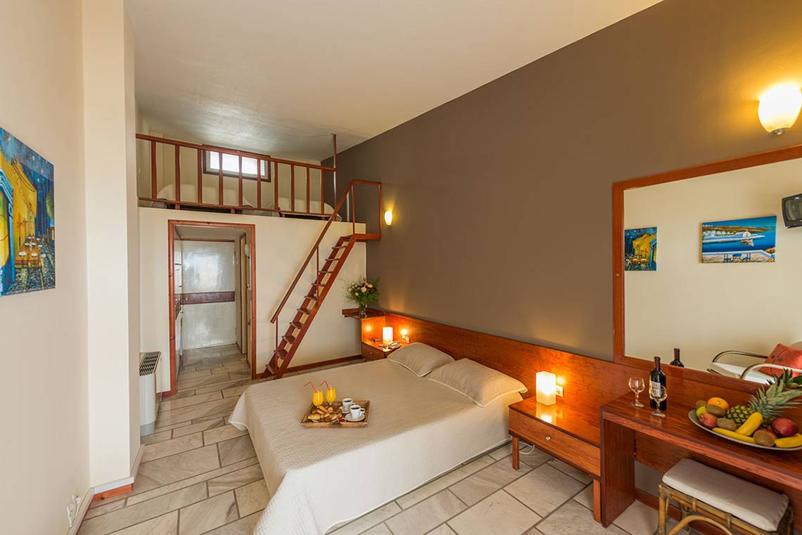 Ein Hotelzimmer von Pavlina Beach mit einem Doppelbett, Balkon, und Frühstücksangebot.