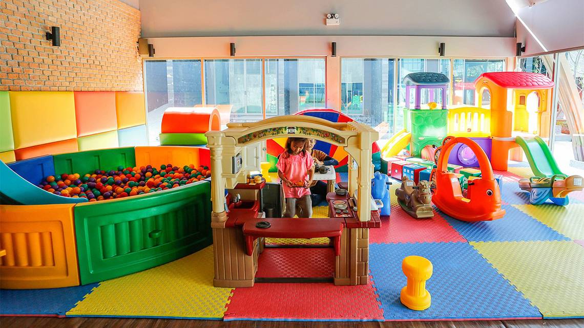 Ein buntes Kinderspielzimmer im Kalima Resort & Villas Khao Lak mit verschiedenen Spielgeräten und einer Spielküche.