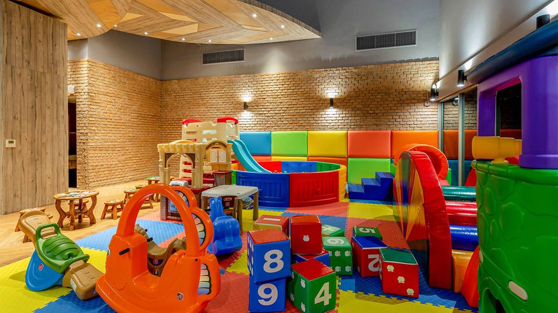 Kinderspielbereich im Kalima Resort & Villas Khao Lak mit bunten Spielgeräten und Spielzeug.