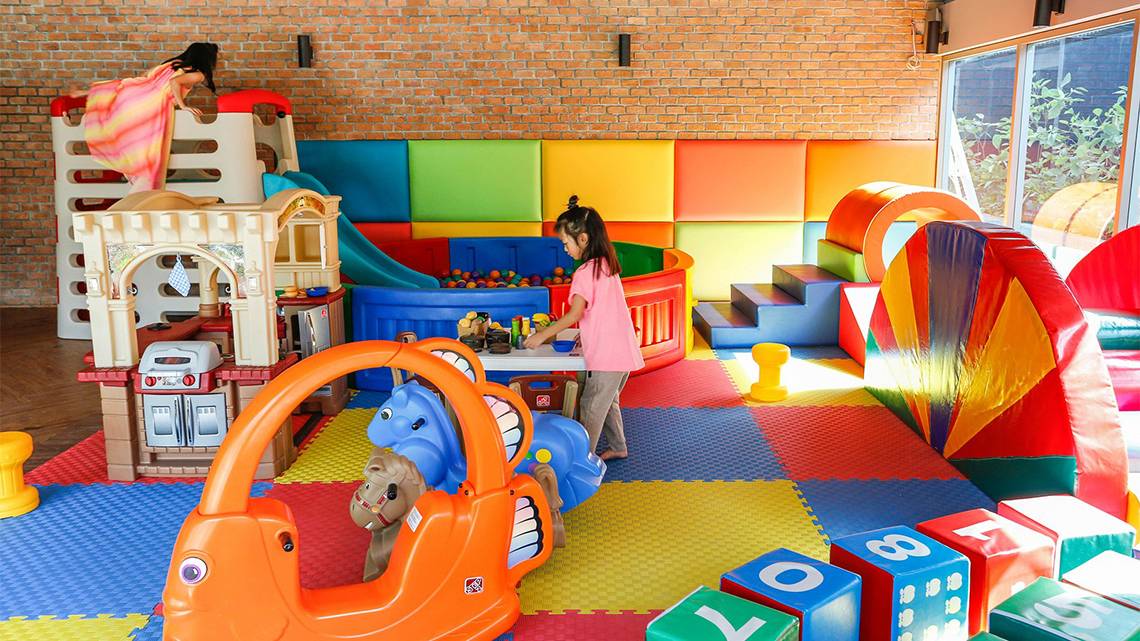 Kinderspielbereich im Kalima Resort & Villas Khao Lak mit bunten Spielsachen und Rutschen.