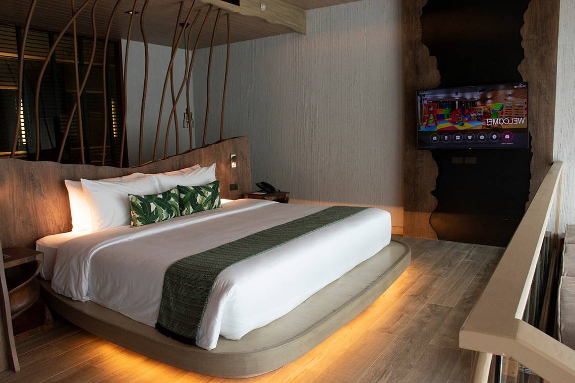 Schlafzimmer im Kalima Resort & Villas Khao Lak mit Kingsize-Bett, Fernseher und Nachttisch