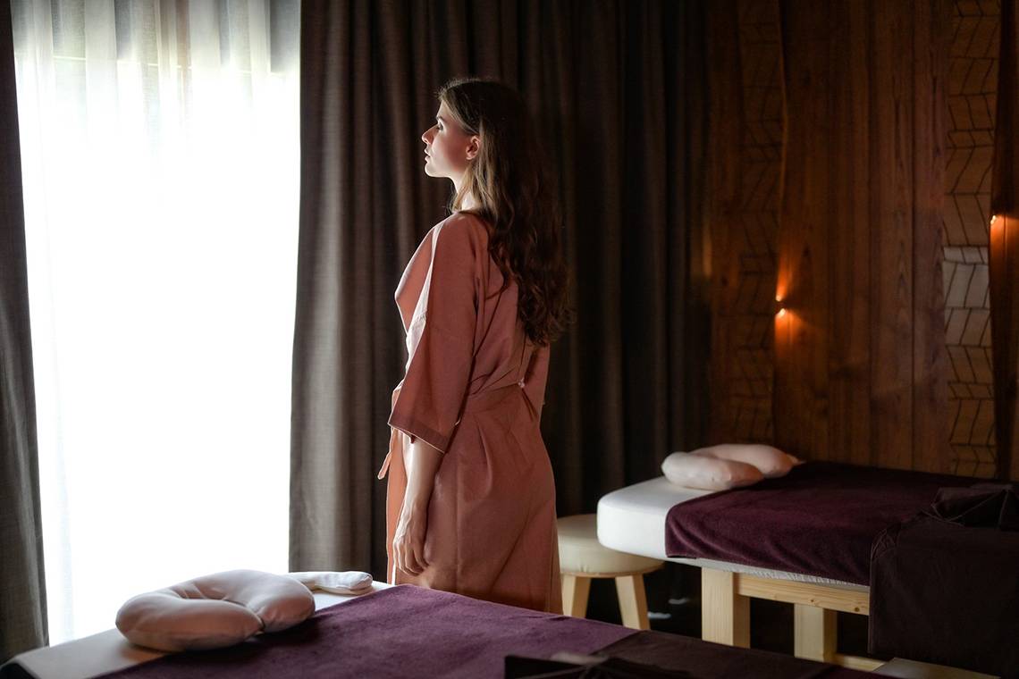 Frau im Spa-Bereich des Kalima Resort & Villas Khao Lak, die in die Ferne schaut.