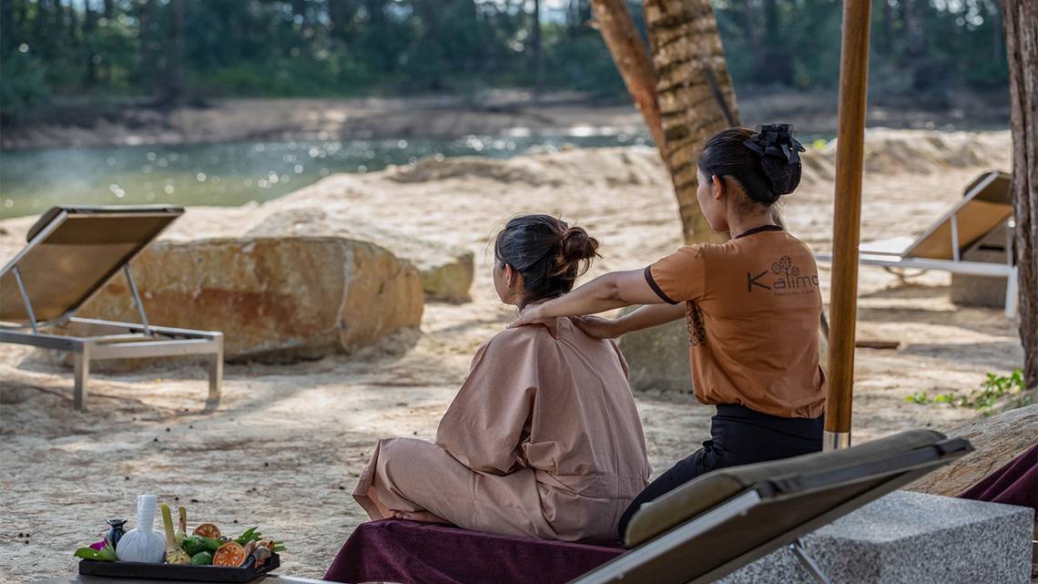 Eine Frau genießt eine Massage am Strand im Kalima Resort & Villas Khao Lak.