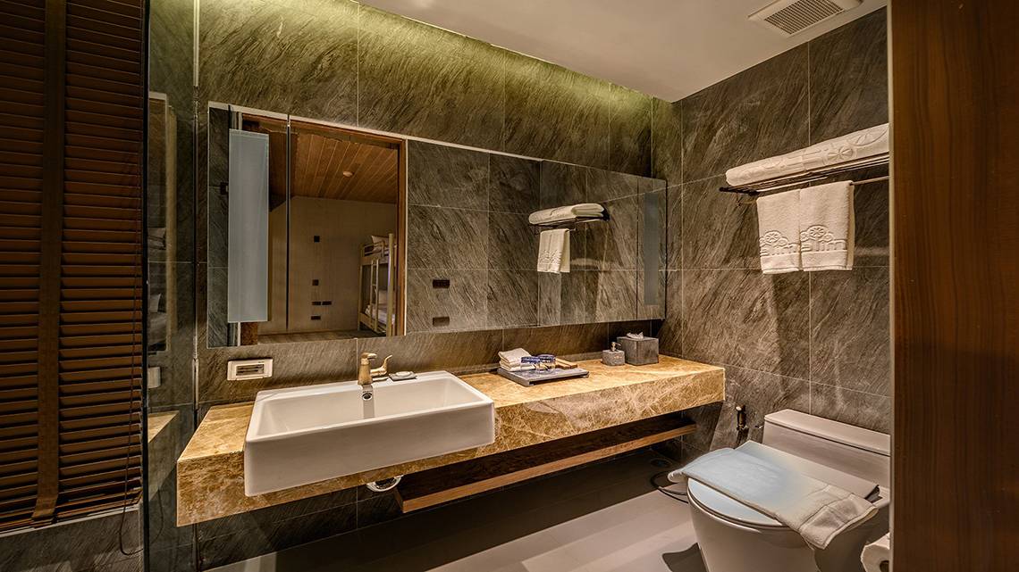 Das Badezimmer im Kalima Resort & Villas Khao Lak mit einer weißen Badewanne und einem Waschbecken.