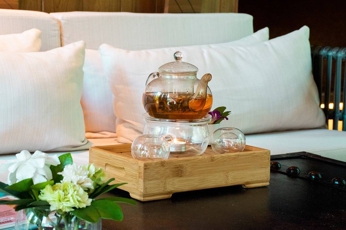 Ein Teeservice auf einem Holztablett auf einem weißen Sofa im Kalima Resort & Villas Khao Lak