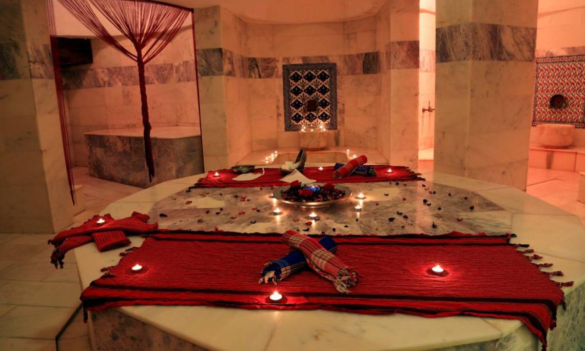 Innenansicht des LABRANDA Ephesus Princess Hammam mit rotem Teppich, Kerzen und Marmorwänden.