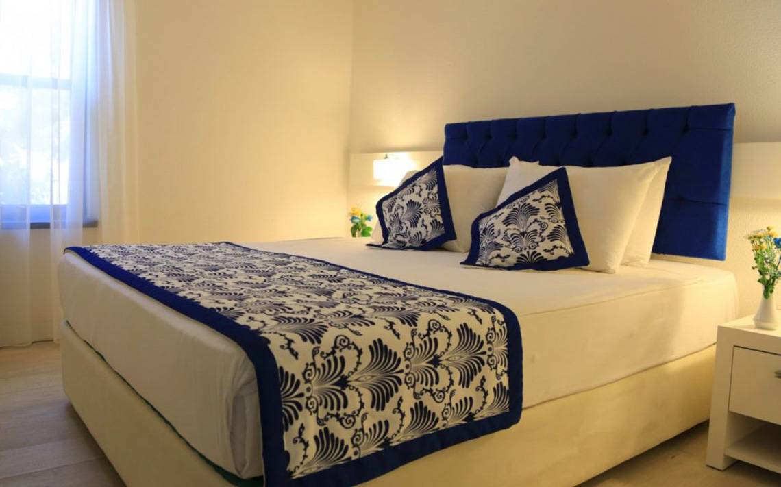 Hotelzimmer im LABRANDA Ephesus Princess mit weißem Bett und blauen Kissen