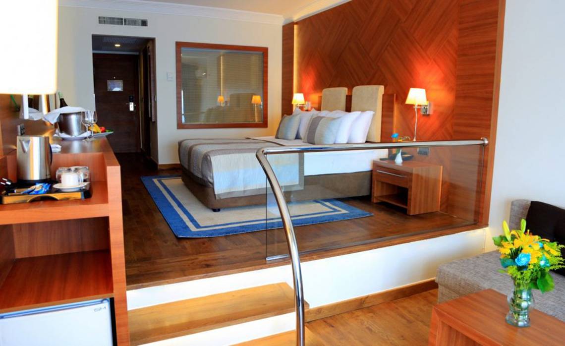 Innenansicht eines Hotelzimmers im LABRANDA Ephesus Princess Hotel mit Doppelbett, Schreibtisch und Minibar.