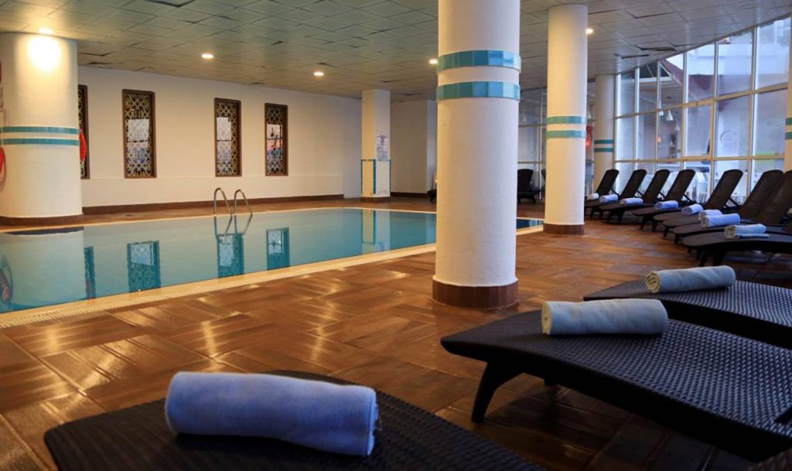 Innenpool im LABRANDA Ephesus Princess Hotel mit Lounge-Sesseln und Handtüchern.
