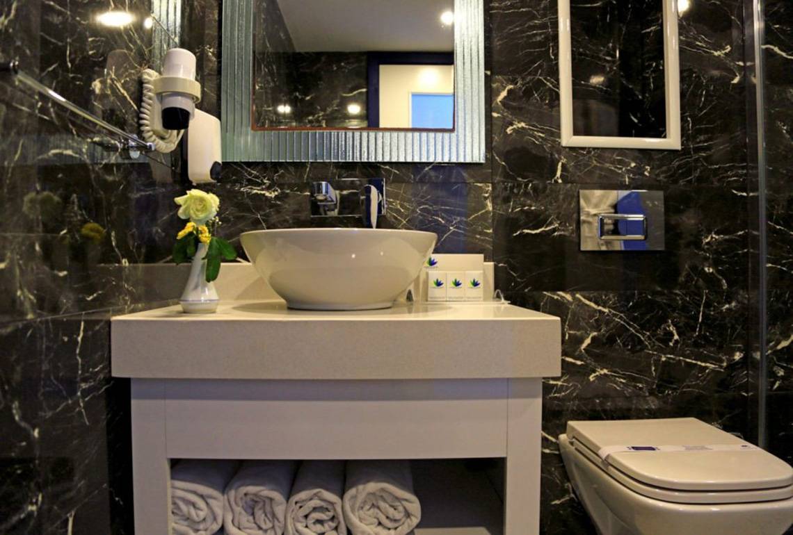 Badezimmer im LABRANDA Ephesus Princess Hotel mit schwarzem Marmor und weißen Möbeln.