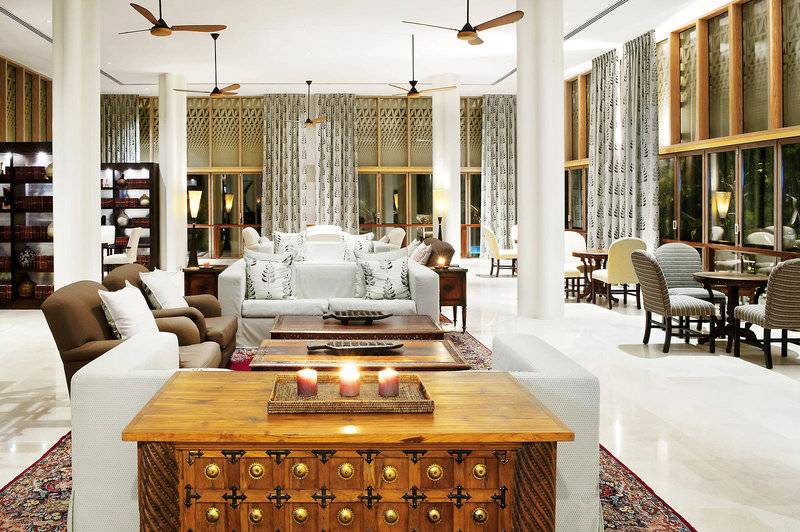 Innenbereich des Melia Zanzibar Hotels mit Sofas, Tischen, Stühlen und Deckenventilatoren.