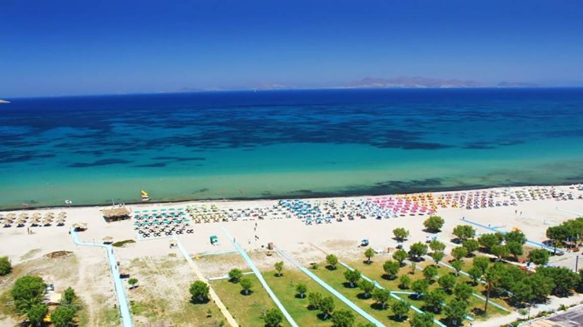 Ilios K. Village Resort Strand mit vielen Sonnenschirmen und Liegen