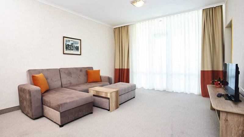 Wohnzimmer im Festa Panorama Hotel mit Sofa, Couchtisch und Fernseher.