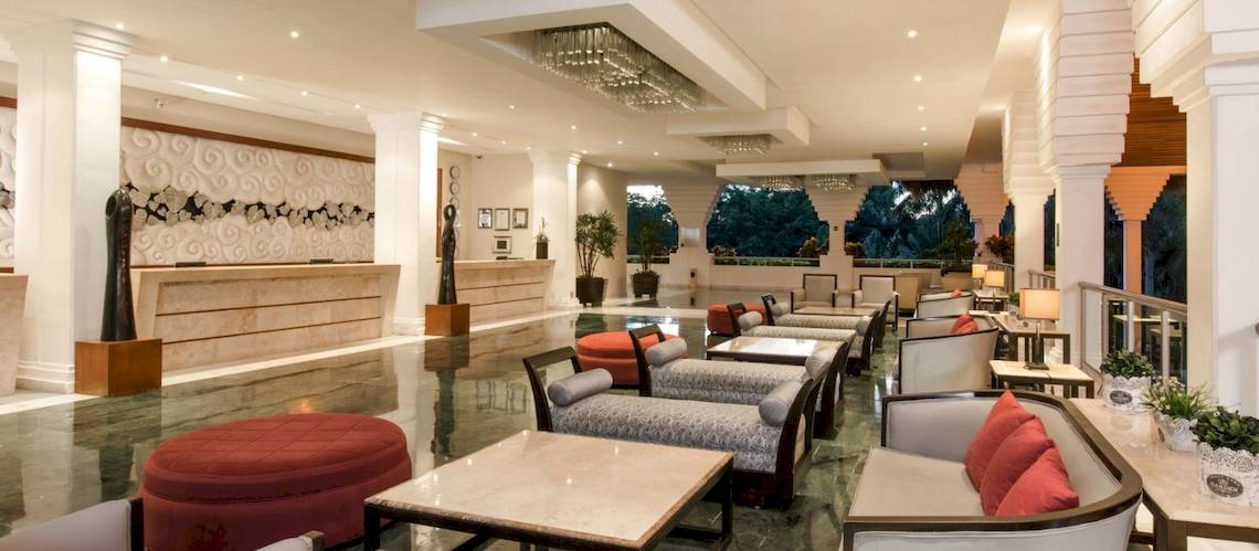 Grand Riviera Princess Hotel Lobby mit Rezeptionstresen, Sitzbereichen und Pflanzen.