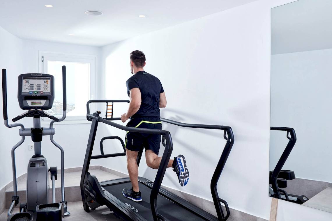 Mann auf einem Laufband im Fitnessraum des Absolute Mykonos Suites & More